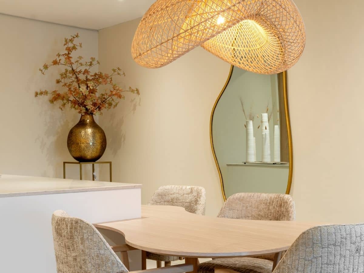 Impressie van een Japandi keuken, voorzien van een eettafel en lamp met organische vormen.