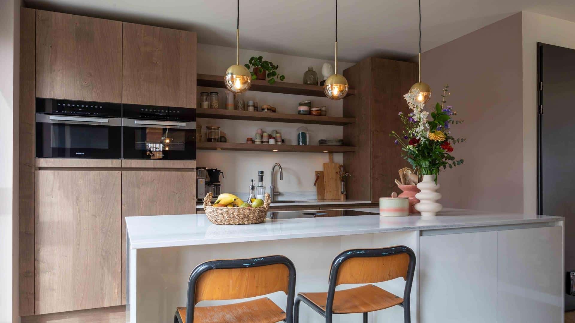 Impressie van een mediterrane keuken met natuursteen blad en terracotta accenten.