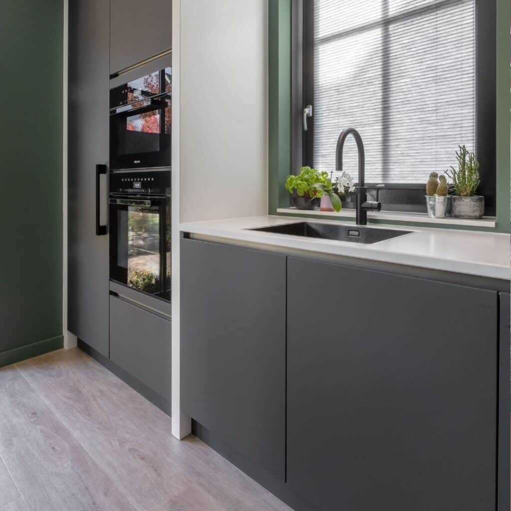 Moderne keuken met zwart-wit aanrecht en zwarte Quooker.