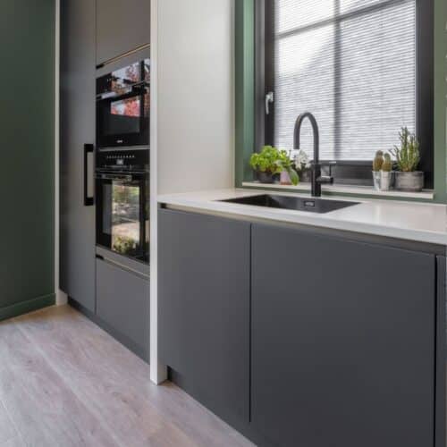 Moderne keuken met zwart-wit aanrecht en zwarte Quooker.