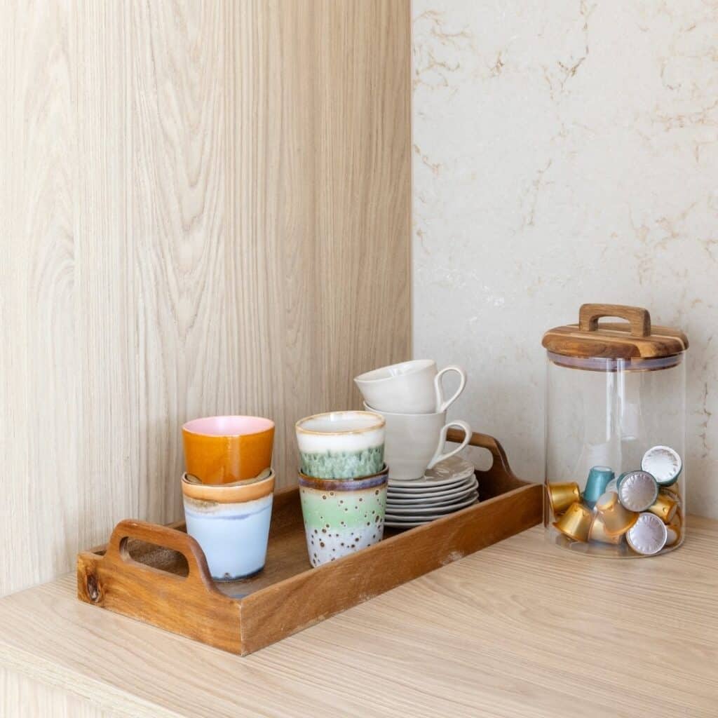 Close-up in een keuken nis van licht eiken, met een natuursteenlook achterwand.