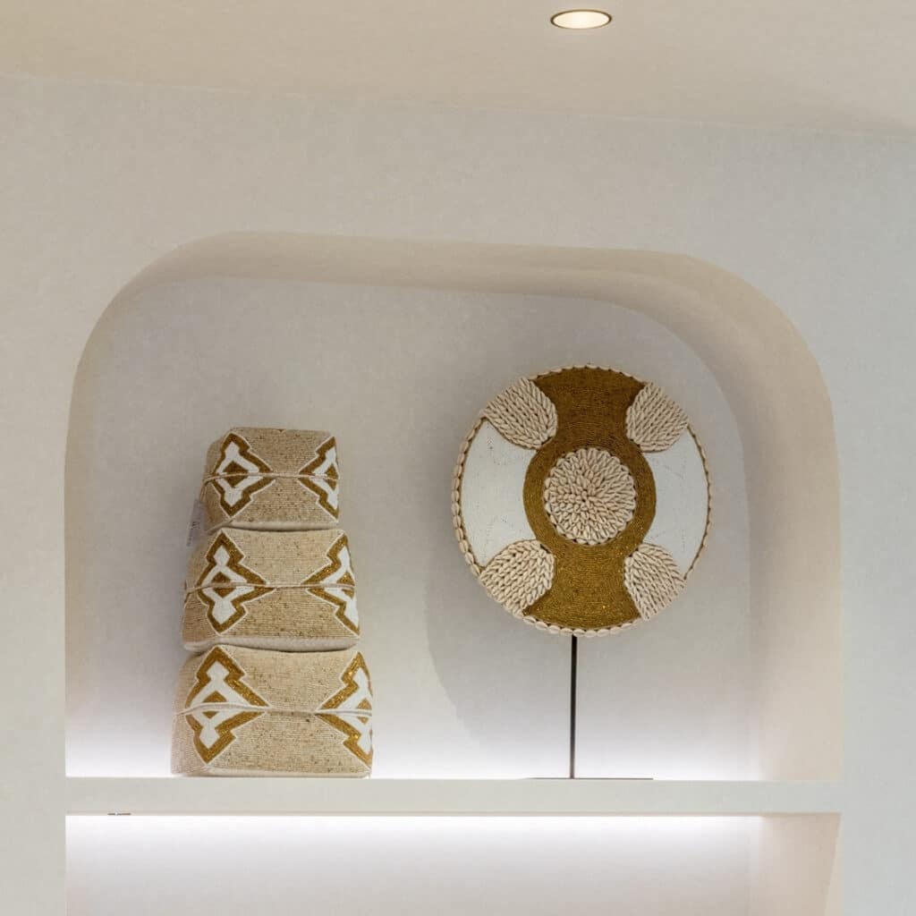 Close-up van een smalle nis in een Japandi keuken met ronde hoeken. De nis heeft een plank met verlichting en decoraties in organische vormen en aardetinten.