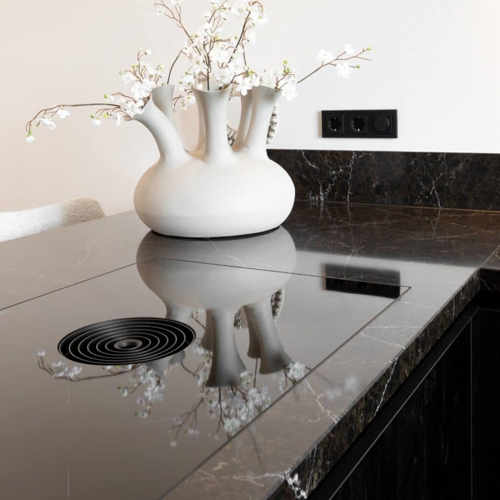 Impressie van een zwart marmerlook werkblad, voorzien van een Bora kookplaat met werkbladafzuiging.