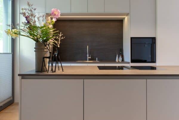 Impressie van een strakke moderne keuken met nis en kookeiland.