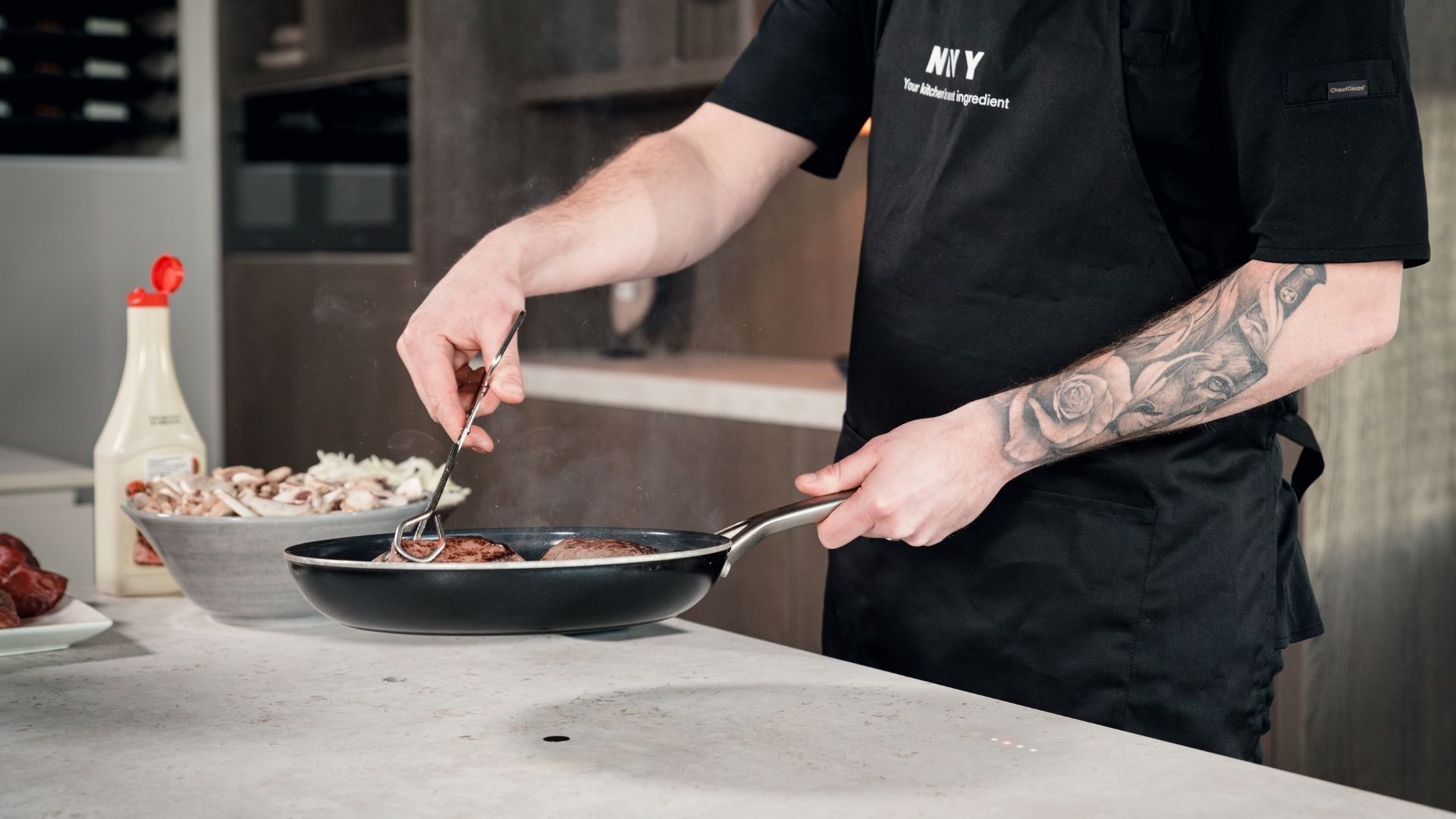 Een kok is aan het bakken op de Novy Undercover, een onzichtbare kookplaat die geheel is weggewerkt in het keukenblad.