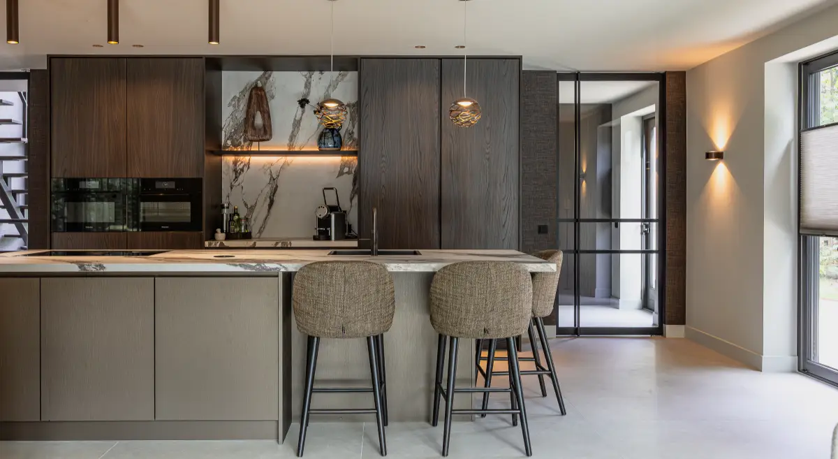 Moderne leefkeuken met kookeiland en bar, afgewerkt met luxe materialen zoals marmer en brons in een Hotel Chique stijl